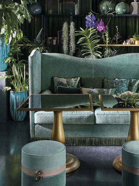 Divano Allure di Angelo Cappellini verde a schienale alto con pouf rotondi dorati, ispirazione per un salotto classico italiano
