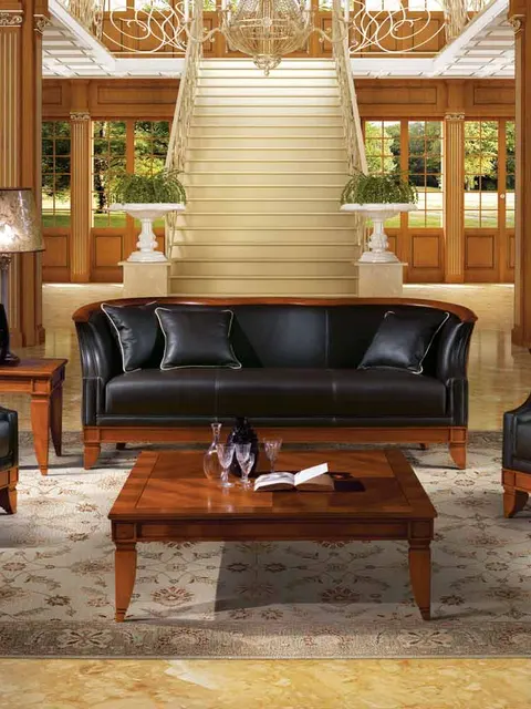 Divano e poltrone Angelo Cappellini in pelle nera in un salotto rivestito in boiserie, design italiano classico