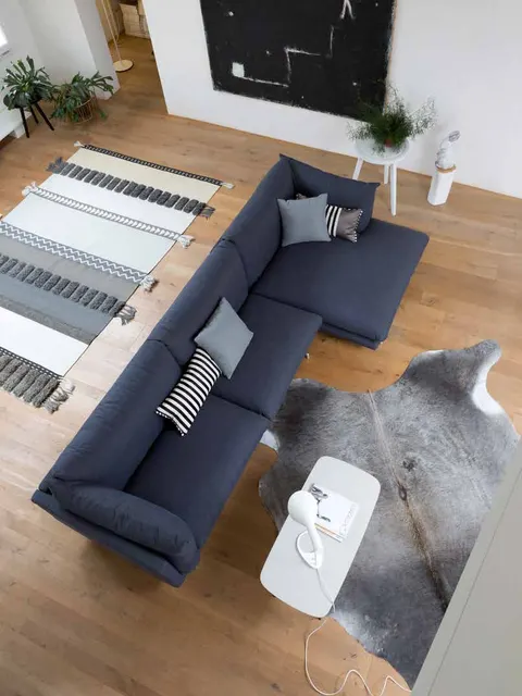 Divano angolare Dall'Agnese blu notte su pavimento in legno con tappeto a righe, idee di divani angolari per il soggiorno di famiglia