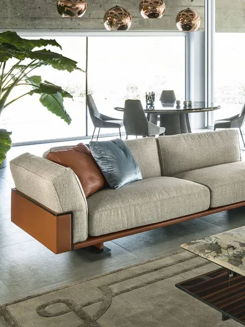 Divano Longhi avorio su base in pelle cognac davanti a una finestra sul giardino, divano italiano contemporaneo per casa