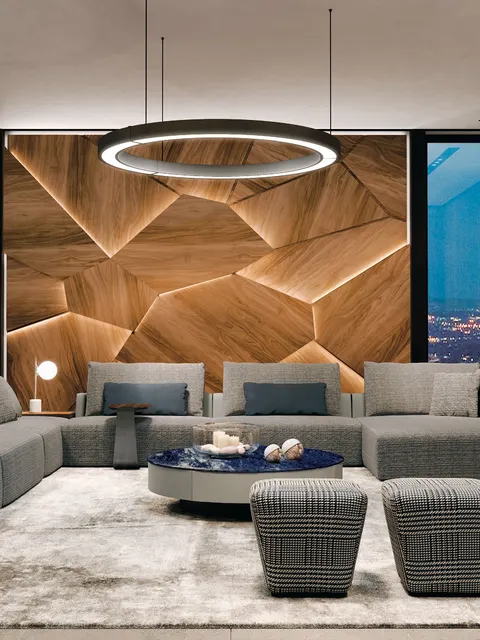 Divano componibile Utopia di Pregno grigio con poltrone davanti a una parete in legno sfaccettata, idea di soggiorno moderno