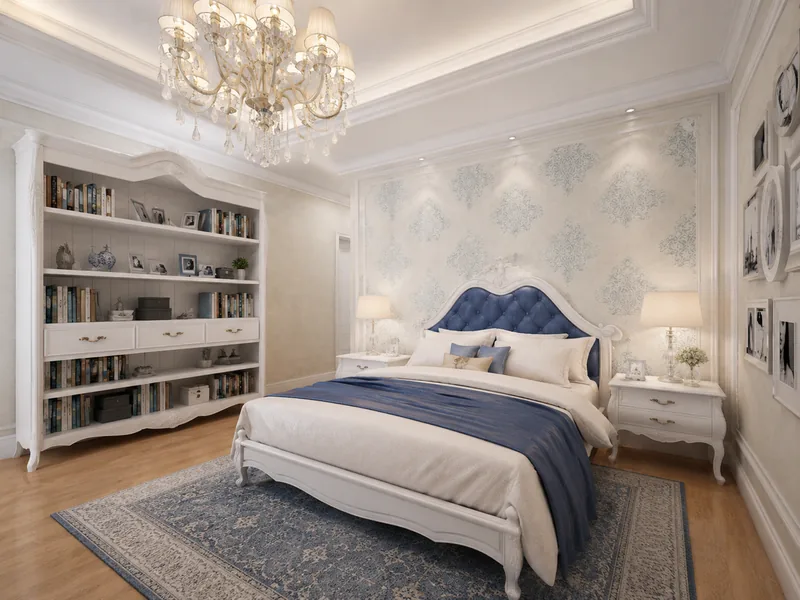 Classic guest bedroom with white carved bed, navy tufted headboard, white bookcases and damask wallpaper
