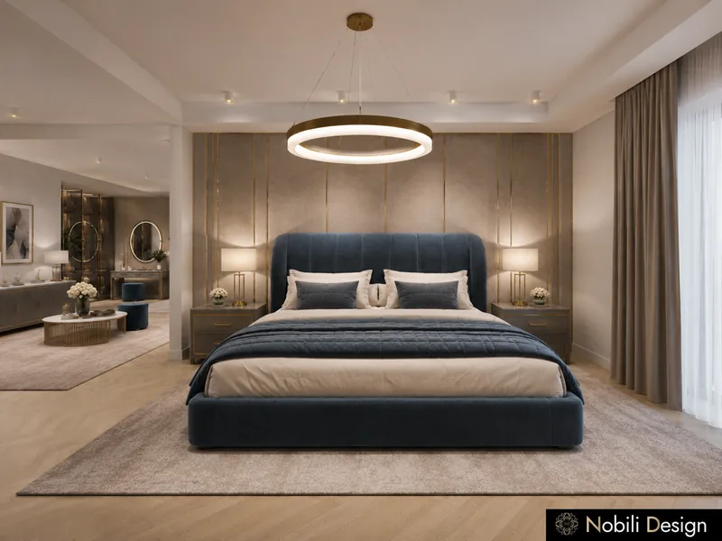 Navy velvet upholstered bed under a ring pendant in a hotel suite with panelled walls and bedside lamps