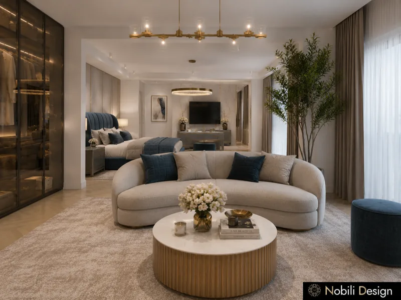 Hotel suite lounge with curved sofa, round marble table, brass chandelier and a lit glass walk-in wardrobe