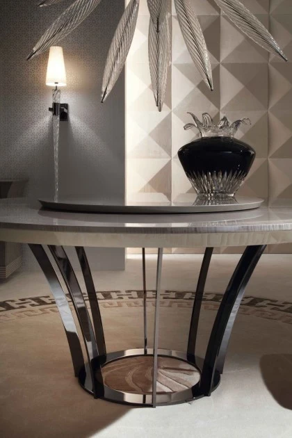 Minimalist round dining table featuring a central pedestal base and a luxurious polished tabletop finish.