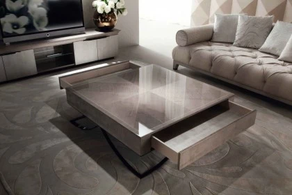 Geometric square cocktail table with a luxury finish acting as a central anchor for seating.